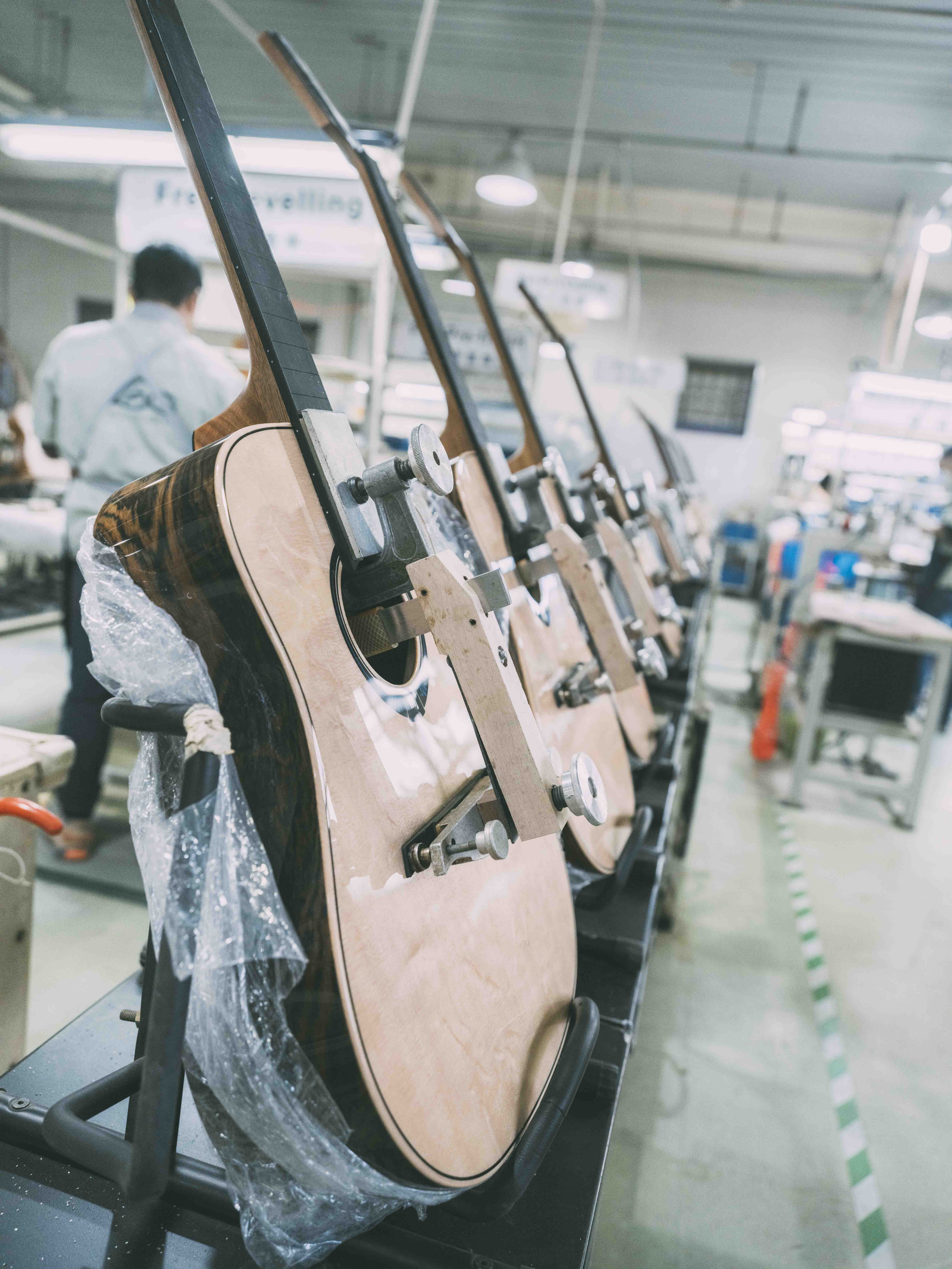 Processus de sèche de la colle de la touche et du chevalet de guitare Lâg THV30DCE dans l'usine Lâg à Tianjin
